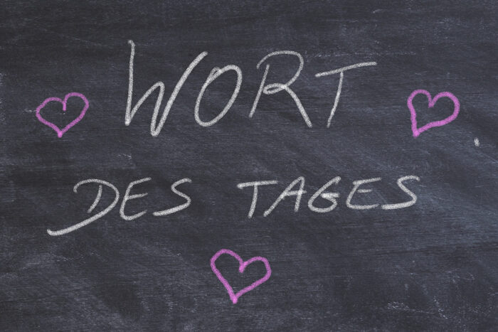 Auf diner schwarzen Tafel steht mit Kreide geschrieben: Wort des Tages